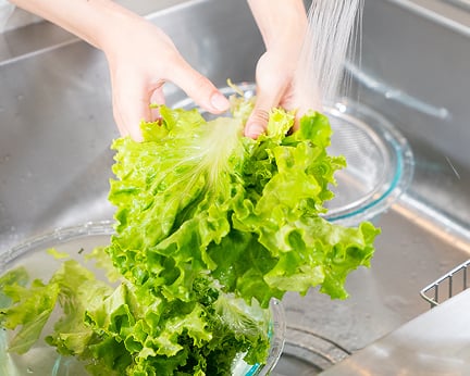 野菜を水道で洗う手元